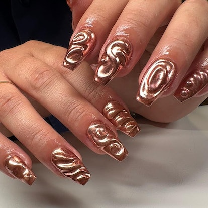 Rose gold, textured nails are a trendy 3D chrome nail design.