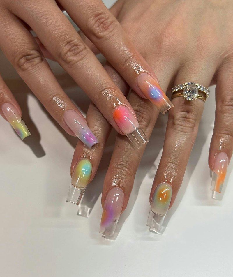 Here are trendy ideas for clear nails, like these aura nails in pretty shades of orange and purple.