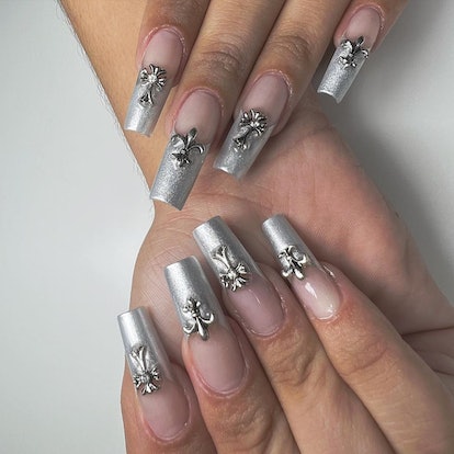 Early 2000s-inspired silver crosses that match the 3D chrome nail art trend.