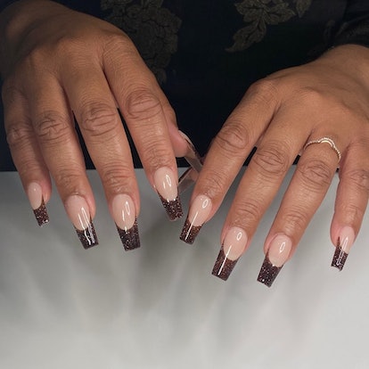 Glittering dark chocolate French nails that match the cabincore aesthetic.