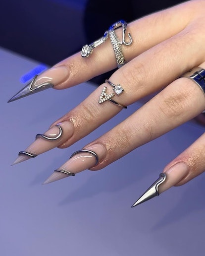 Ultra-sharp stiletto nails with silver details that match the 3D chrome nail art trend.