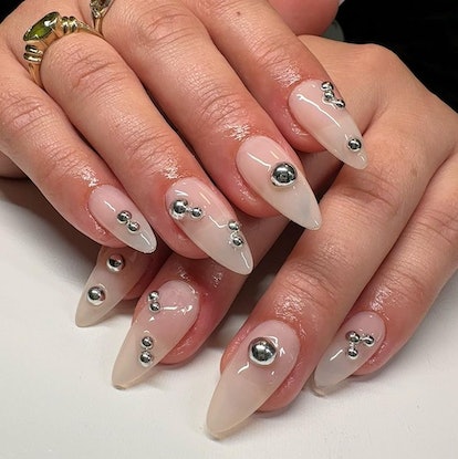 A manicure design with stainless steel studs that match the 3D chrome nail art trend.