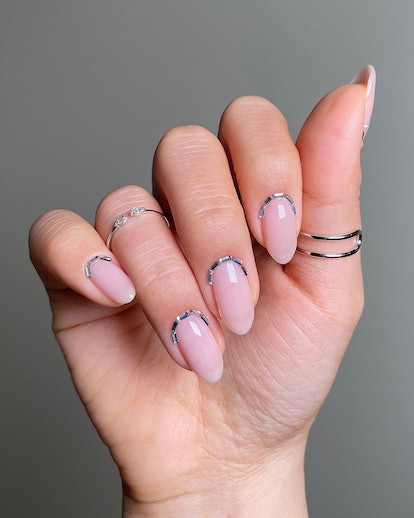 Minimal silver nail cuffs that match the 3D chrome nail art trend.