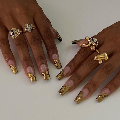 Golden French nails with architectural texture that match the that match the 3D chrome nail art tren...