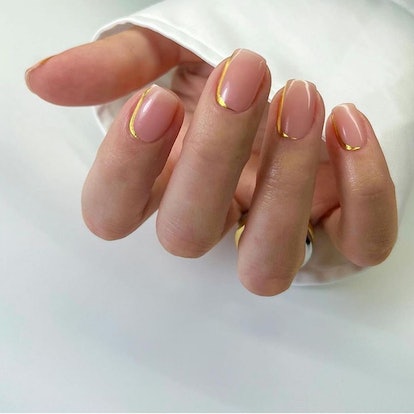 If you need manicure inspo, easy gold lines on clear nails are a simple short design that's on-trend...