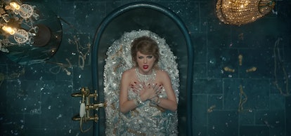 Taylor Swift wears a sleek side part, red lips, and is covered in silver jewels in the "Look What Yo...